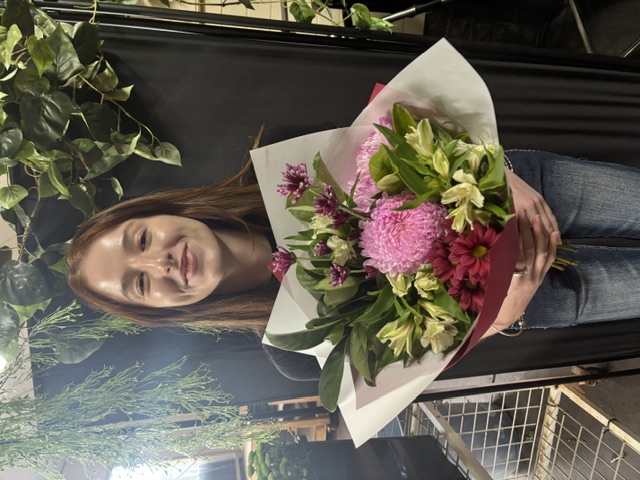 A member of the Rodano Flowers team holding a fresh hand-tied bouquet